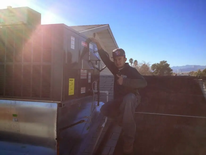 HVAC technician performing Boiler Repair on a rooftop unit in Highland Heights